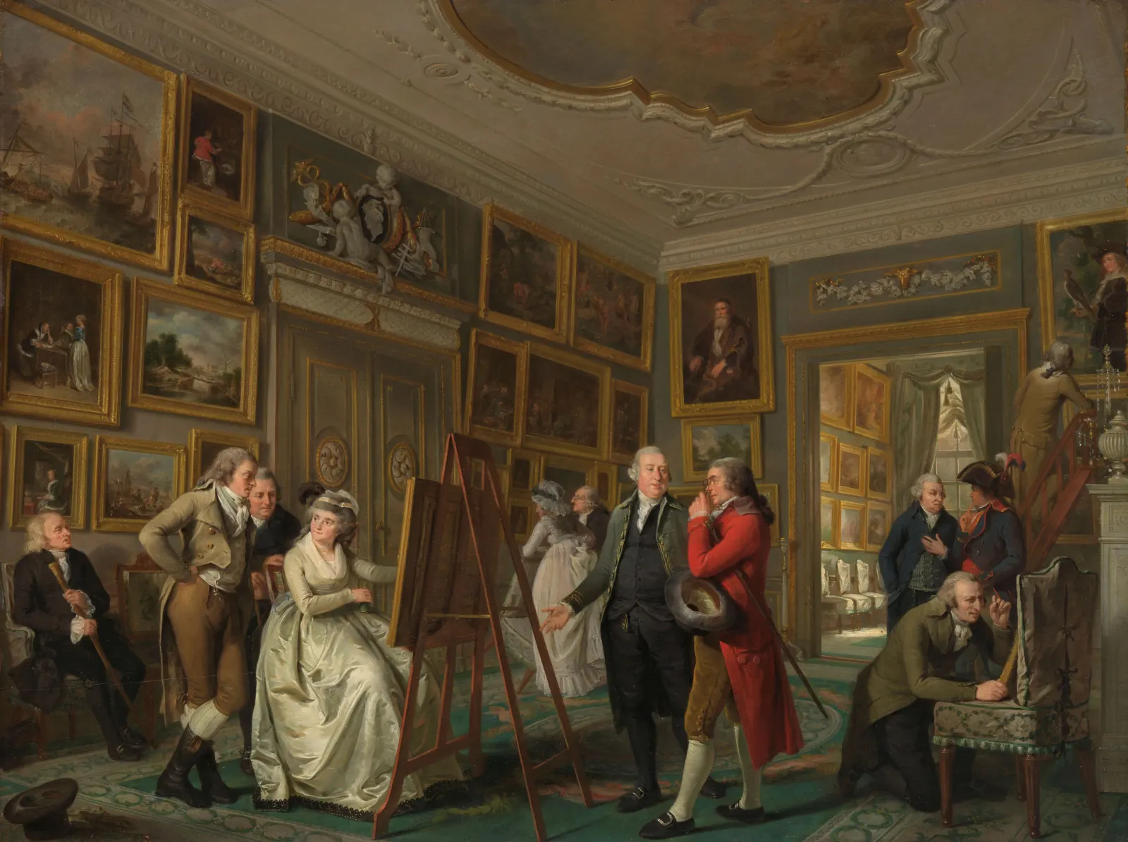 Visitors in late eighteenth-century dress gather in a picture gallery hung frame to frame with paintings; a woman sits before a painting on an easel while the host greets a guest in a red coat.